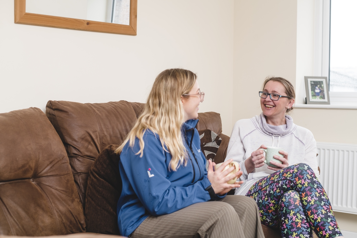 Sue alongside on of our colleagues in her home.