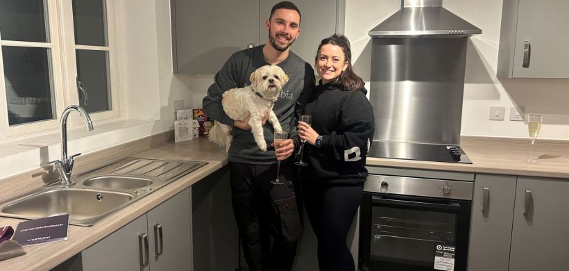 Sarah and Ashley with their dog inside their new kitchen.