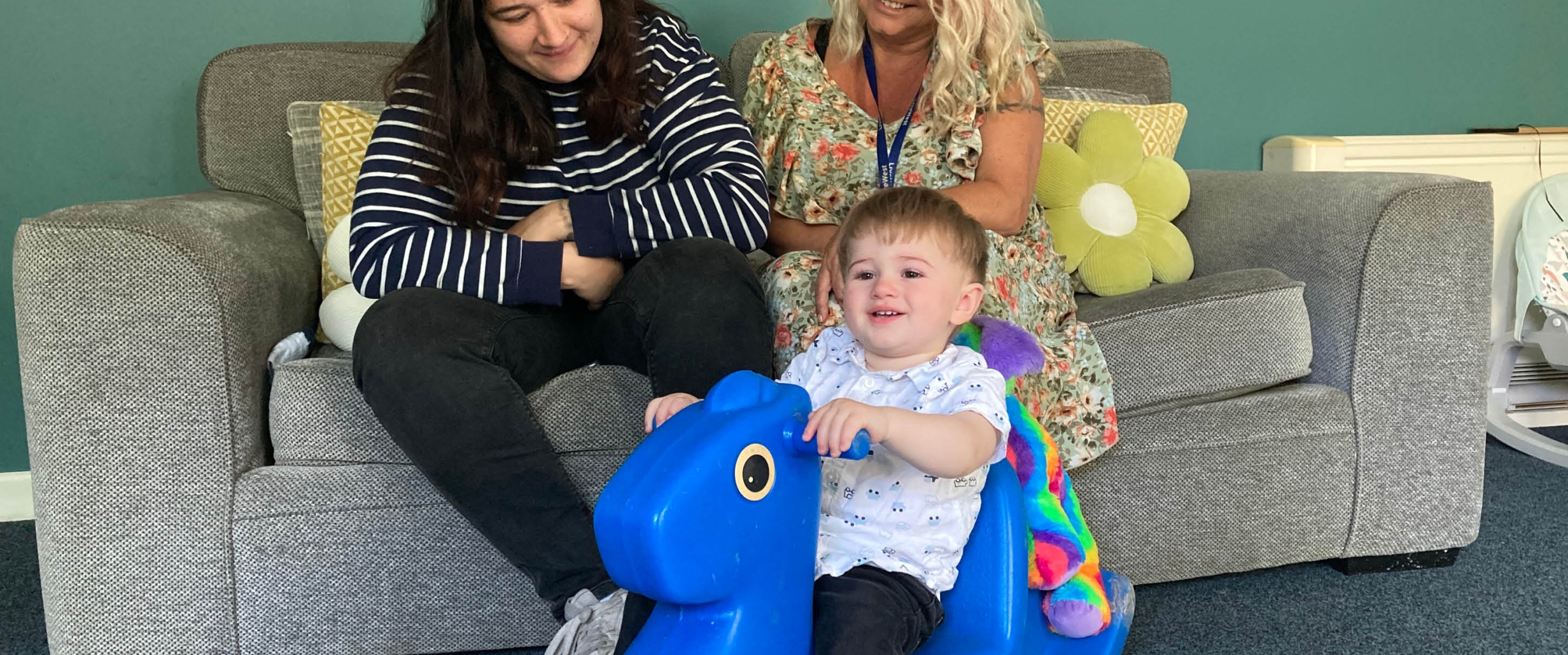 A resident in Carthew House with a child and LiveWest colleague. 