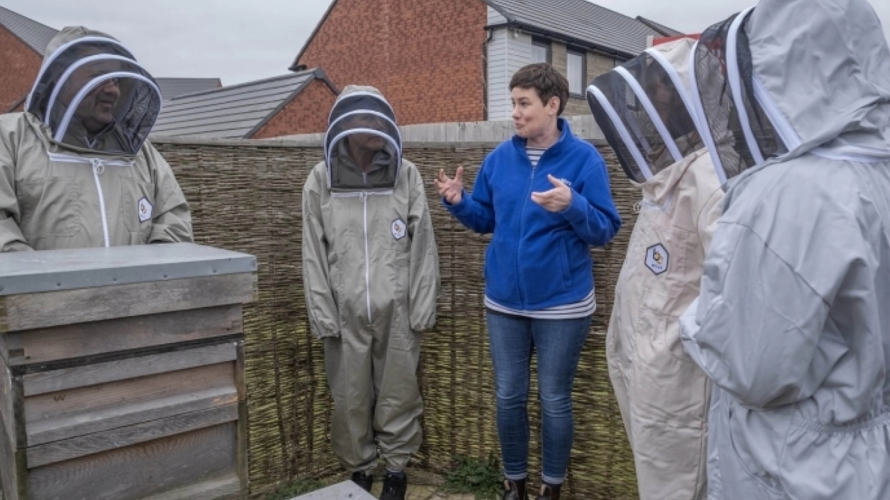 LiveWest colleague with resident volunteer beekeepers. 