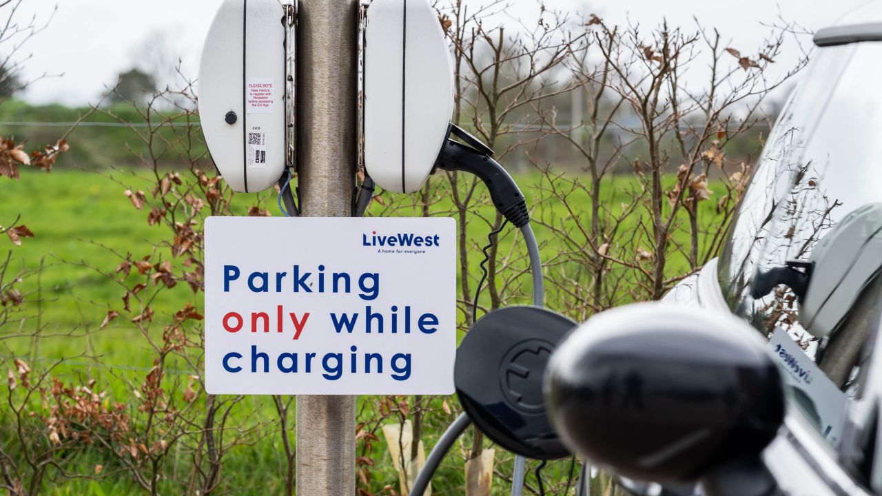 Image of a parking sign next to a car. 