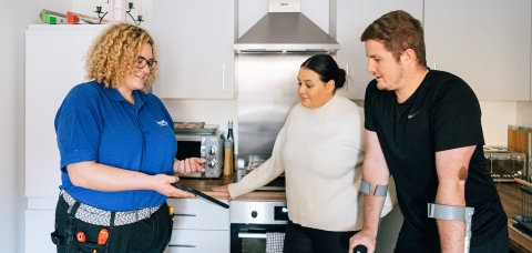 LiveWest colleague talking with two customers in a kitchen. 