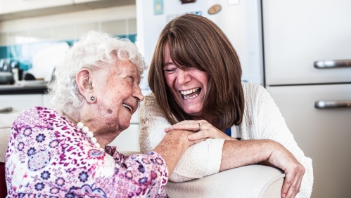 Delcie (left) smiling alongside one of our supported housing colleagues.