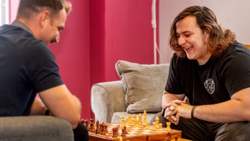 Braedon right happily playing chess with one of our support workers at the scheme.