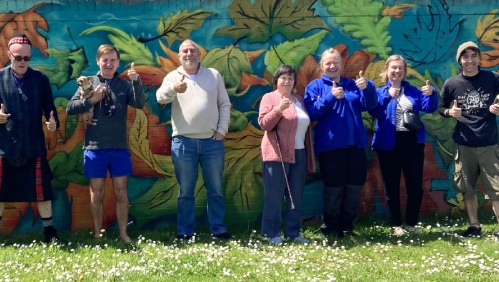 Local residents and LiveWest colleagues smiling in front of the new wall art.