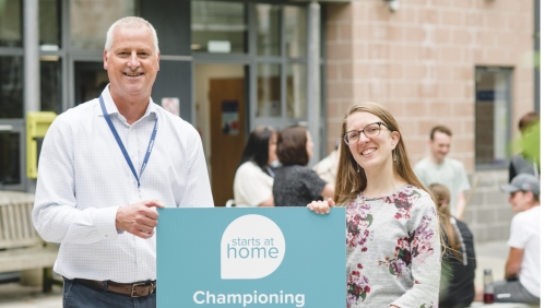 James Reseigh, LiveWest's Director of Neighbourhoods, and Suzannah Young, National Housing Federation's Policy Leader, smiling with a Starts at Home Day sign.