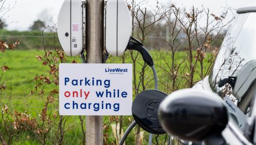 Image of a parking sign next to a car. 